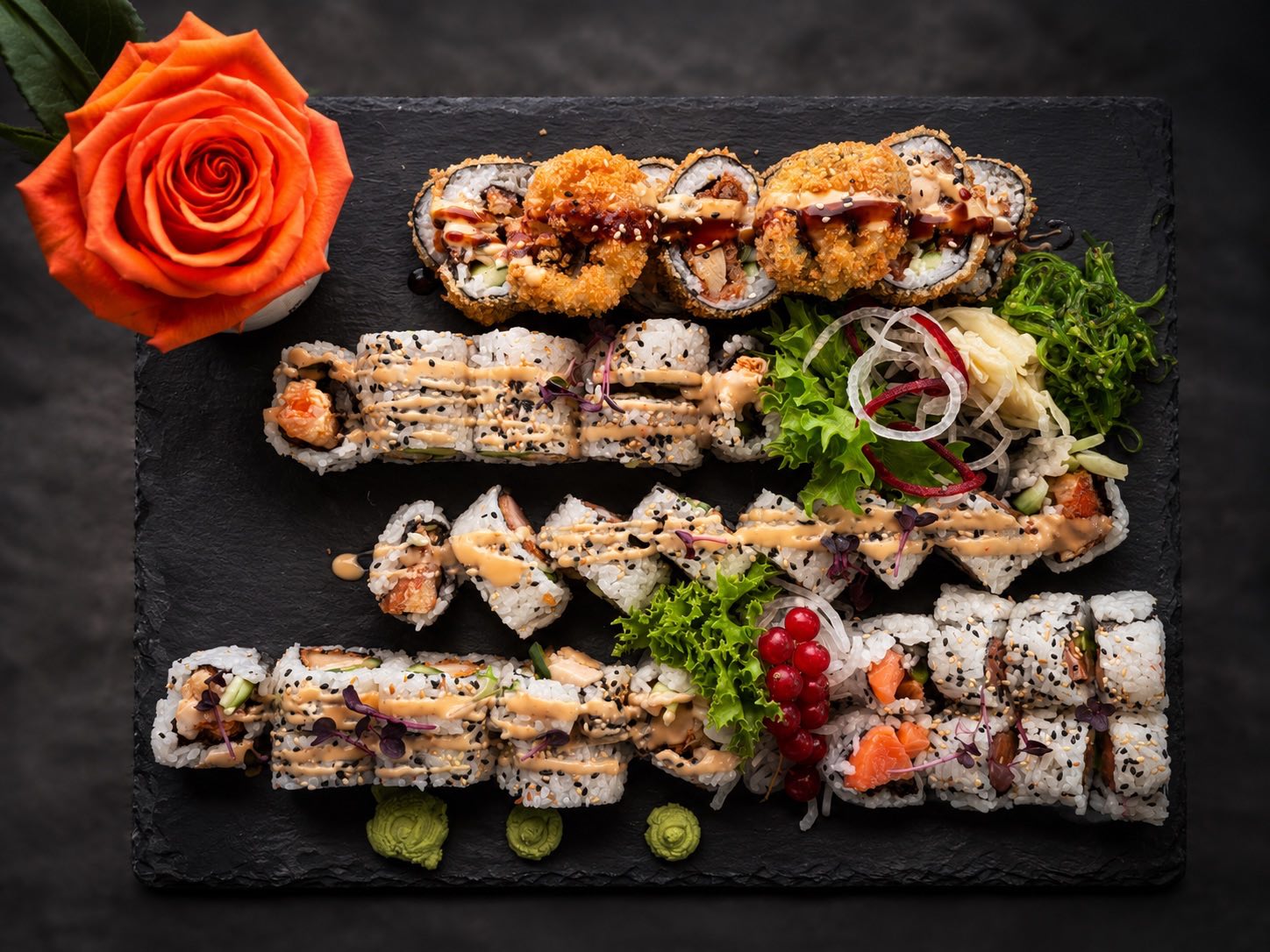 Große Sushi-Platte für zwei mit Tempura-Rollen, Inside-Out-Rollen, Maki und Wakame-Salat